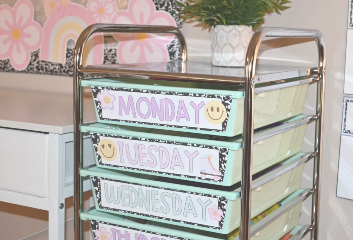 Cart with labeled drawers for each day of the week in a classroom setting.